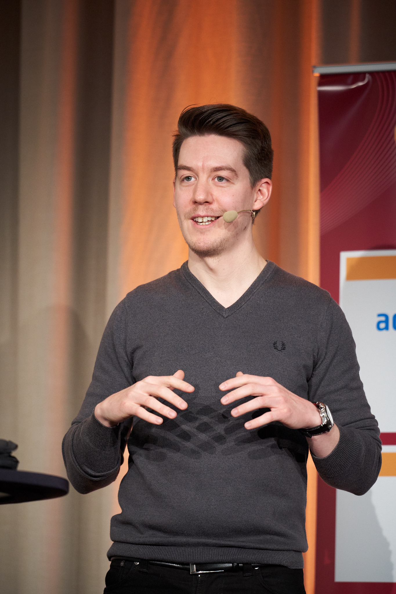 Fabian standing on stage and speaking during a conference session.
